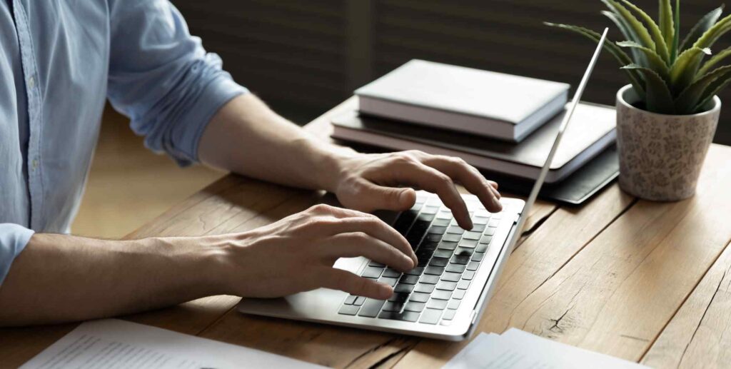 Close up businessman using laptop, sitting at work desk